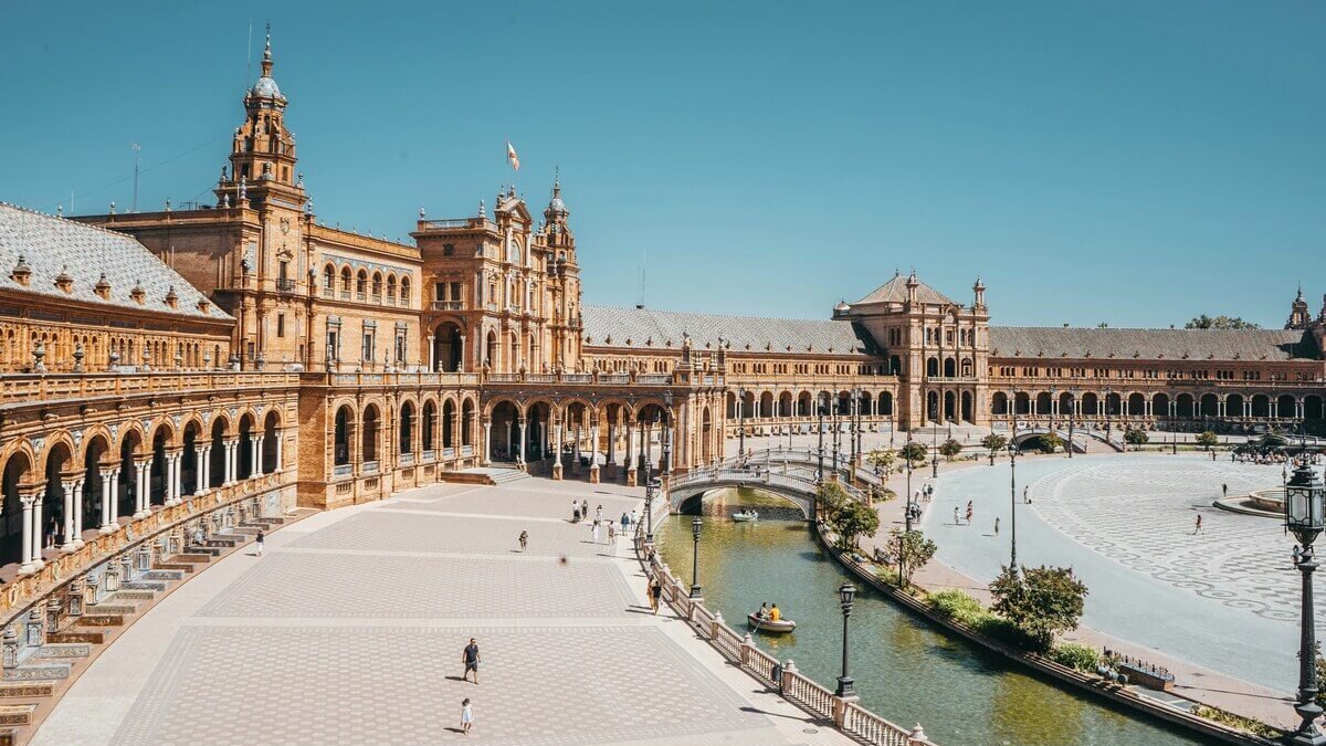 Wide view of Plaza de España in Seville, Spain, featuring the canal and Renaissance Revival architecture.