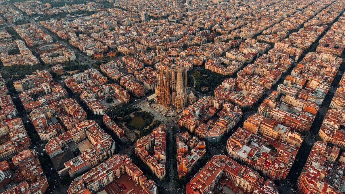 Breathtaking aerial view of the Sagrada Familia basilica and the unique grid-patterned Eixample district in Barcelona.
